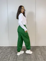 Pantalón babucha verde oliva de corte holgado, con cintura elástica, terminaciones elásticas en los tobillos y bolsillos cargo laterales.