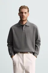 Polo manga larga negro de algodón con elasticidad y estructura. Cuello solapa con cierre frontal de botonadura y acabados con rib.