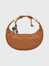 Bolso hobo de cuero color marrón, con cierre de solapa con botón a presión y correa corta para llevar al hombro. Incluye charm colgante con cuentas de madera y piedra.