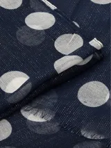 Bufanda rectangular azul marino con lunares blancos y terminación con flecos.