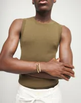 Pulsera rígida de aleación de metales bañada en oro de 18k, con forma de tubo abierto.