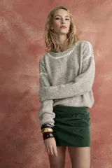 Sweater de punto color beige con cuello redondo y diseño geométrico en blanco.