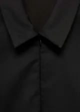 Vestido corto negro con cuello camisero, cierre frontal con cremallera, mangas cortas y corte entallado.