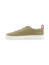 Zapatillas bajas color verde oliva, de cuero descarne, con cordones de cinta al tono y suela blanca.