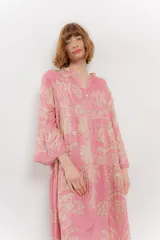 Vestido largo azul con estampado floral en tonos beige, confeccionado en viscosa. Presenta escote en V, botonadura completa en el frente y mangas largas con volados.
