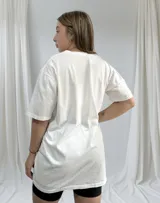 Remerón blanco de corte holgado con estampa de hibisco azul y texto en negro.