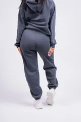 Pantalón de jogging color beige con cintura elástica y logo bordado en la pierna.