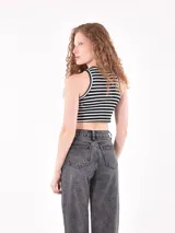 Musculosa de rayas negras y blancas, con corte cropped y detalles de botones en los costados.