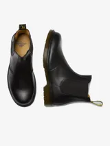 Bota Chelsea de cuero negro, sin cordones, con refuerzos elásticos y suela resistente.