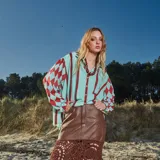 Camisa celeste con rayas verticales rojas y mangas con rombos rojos.