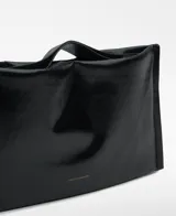 Bolso de mano rectangular color naranja brillante, con asa de mano y asa larga regulable extraíble. Tiene un compartimento con cierre magnético y logo grabado.