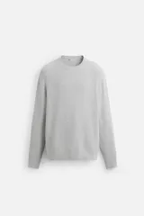 Jersey gris de algodón con cuello redondo, manga larga y terminaciones en rib.