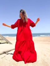 Vestido largo color rojo, con escote en V, mangas 3/4 abullonadas y corte escalonado con volantes.