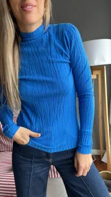 Remera azul de tejido de punto con cuello alto y mangas largas.