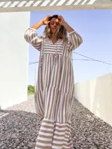 Vestido largo tipo túnica con rayas verticales color beige y crudo, escote en V con lazos y mangas 3/4.