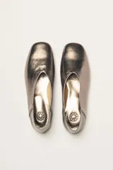 Chatas color beige de cuero vacuno, con talón suave y capellada metalizada.