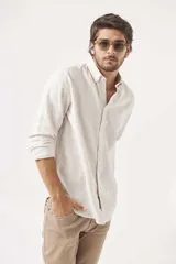 Camisa de lino color blanco, de corte regular, con cuello clásico y mangas largas.