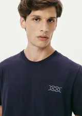 Camiseta blanca de algodón con cuello redondo y mangas cortas. Estampa rectangular con borde negro que contiene la frase "NATURAL ATMOSPHERE" en letras mayúsculas y una imagen de montañas y mar.