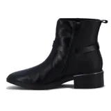 Botas de cuero sintético negro, de caña baja con hebilla decorativa y taco bajo.