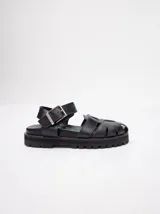 Sandalias negras tipo gladiador con plataforma de goma y hebilla metálica.