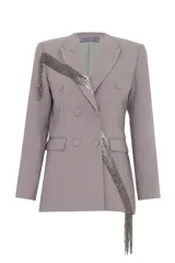 Blazer gris de corte estructurado con doble abotonadura y solapas clásicas. Presenta una aplicación de pedrería en cascada que recorre diagonalmente la prenda.