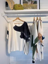 Blusa color crema con estampado de una flor negra y rayas verticales.