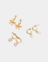 Set de tres pares de aros dorados tipo argolla con dijes colgantes: corazón rosa, perla y moño.