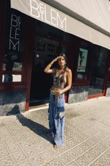 Pantalón cargo oversize de jean con múltiples bolsillos funcionales y detalles metálicos en bronce.