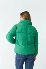 Campera puffer lila de nylon con cuello alto, cierre frontal con cremallera y bolsillos laterales con cierre.