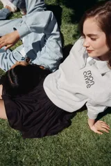 Remera polo gris de corte holgado en tejido felpa liviana con cuello y tapeta de botones. Modelo de manga larga con hombros caídos y ribete acanalado en puños y bajo.