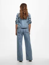 Chaqueta de jean celeste de corte clásico, con mangas largas con puños abotonados, cierre frontal con botones metálicos y bolsillos delanteros con solapa y botón.