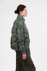 Chaleco verde con estampado de paisajes y cuello alto.