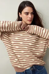 Sweater de punto con diseño de rayas horizontales en relieve color beige y marrón. Tiene cuello redondo y mangas largas.