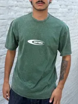 Remera de manga corta color verde oscuro con efecto acid wash y un logo ovalado blanco con el texto "OSTEN" en el centro del pecho.