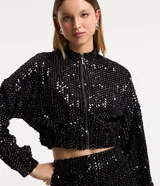 Campera bomber corta negra cubierta de lentejuelas metalizadas, con cuello alto, mangas largas, puños y bajo elásticos, y cierre frontal con cremallera.