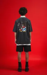 Remera gris oscuro con cuello polo blanco y estampado de Mickey Mouse en el pecho.