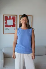 Musculosa sin mangas color azul Francia, con cuello redondo y un pequeño bolsillo en el pecho. El ruedo inferior presenta un detalle de tejido de punto trenzado.
