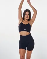 Conjunto deportivo negro compuesto por un top con tirantes finos y logo 'bk.' en el frente, y un short ajustado de tiro alto.