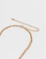 Collar doble dorado con dijes de strass y mariposa.