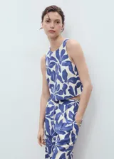 Pantalón largo de tiro medio, corte recto, con pinzas frontales y estampado floral grande en tonos azul y blanco crema.