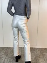 Pantalón plateado de eco cuero, corte recto y tiro medio.