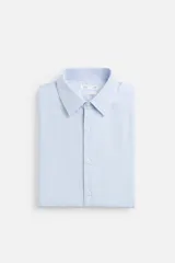 Camisa celeste de algodón, corte regular fit, con cuello italiano, manga larga con puños abotonados y cierre frontal con botones.