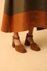 Sandalias de cuero color marrón con plataforma y taco geométrico. Presentan una tira ancha sobre el empeine y pulsera con hebilla al tobillo.