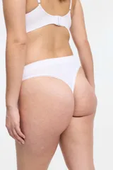 Conjunto de ropa interior blanco, compuesto por un corpiño de breteles finos y una bombacha tipo colaless con detalles de puntilla.