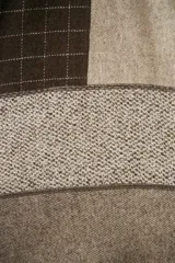 Chal unisex de lana fina sin teñir, realizado con retazos de telas diseñadas por Don Baez. Presenta una grifa de cuero aplicada.