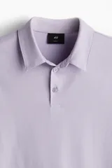 Remera polo lila de punto de algodón liviano, corte ajustado, manga corta, cuello clásico con tapeta de botones y bajo recto.