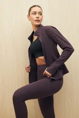 Calza larga color marrón oscuro de tejido técnico elástico, con pretina ancha.