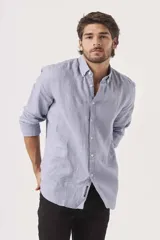 Camisa de lino color blanco, de corte regular, con cuello clásico y mangas largas.