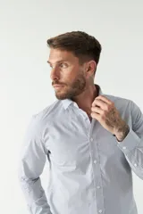 Camisa celeste a cuadros, de corte slim fit, manga larga y logo bordado. Confeccionada en 100% algodón.
