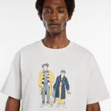 Remera de algodón color gris melange con cuello redondo y manga corta. Estampado frontal con ilustración de dos figuras vestidas con abrigos y accesorios.
